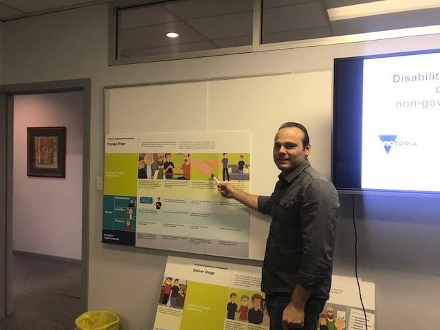 Anthony pointing at the whiteboard with information about the NDIS